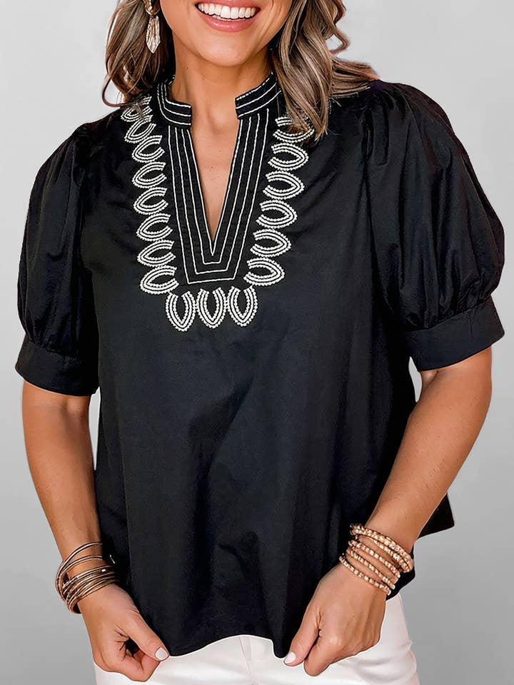 Zwarte blouse met korte pofmouwen, contrasterend geborduurd detail en V-hals. voor wholesale door Lovesoft