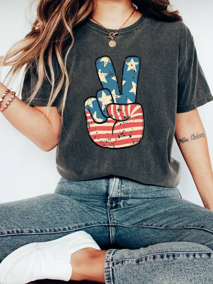 T-shirt graphique en forme de signe de paix du 4 juillet pour la vente par Desert Raine