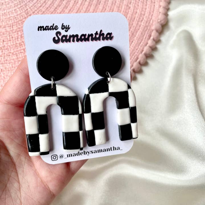 Hängande svartvita örhängen i polymerlera med bågform och schackrutemönster för wholesale av Made By Samantha
