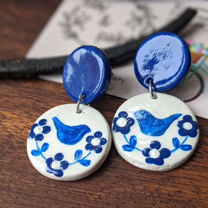 Hand-Painted Folk Art Blue Bird and Flower Earrings for wholesale by With Clay & Paint
