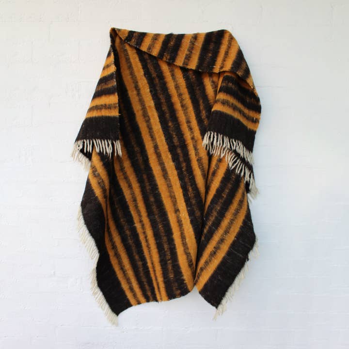 MANTA DE LÃ PRETA E LINHAS OCRE SOBRE CRU por atacado de La Casa Cotzal S.A.