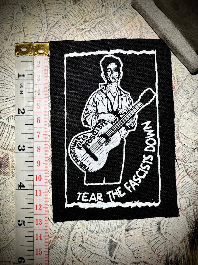 Woody Guthrie-mærke. for engroshandel hos Three Raccoons