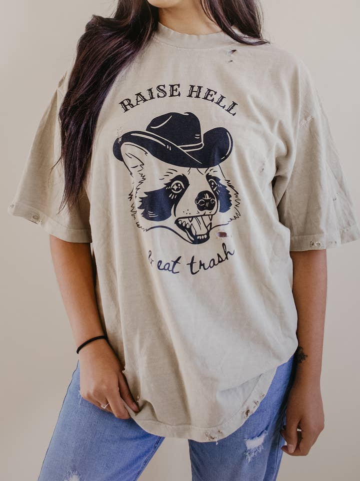 Distressed Raise Hell & Eat Trash Western Racoon Graphic Tee for wholesale by Uncommon Wild