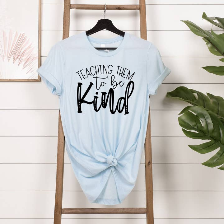 Teaching Them to Be Kind Light Blue Tee Black Ink for wholesale by Simply Tees