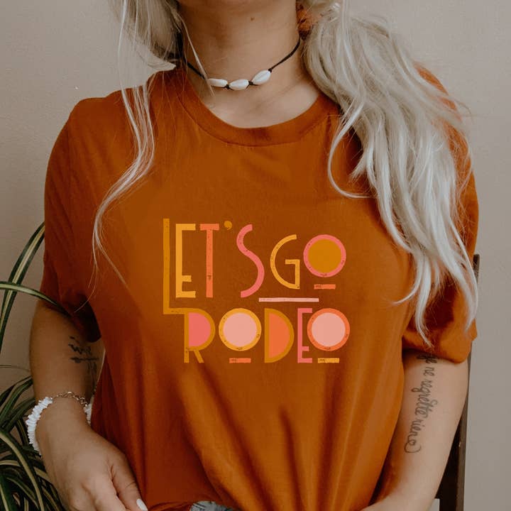 T-shirt unisexe à manches courtes Let's Go Rodeo pour la vente par Dixie Mae Clothing Co.