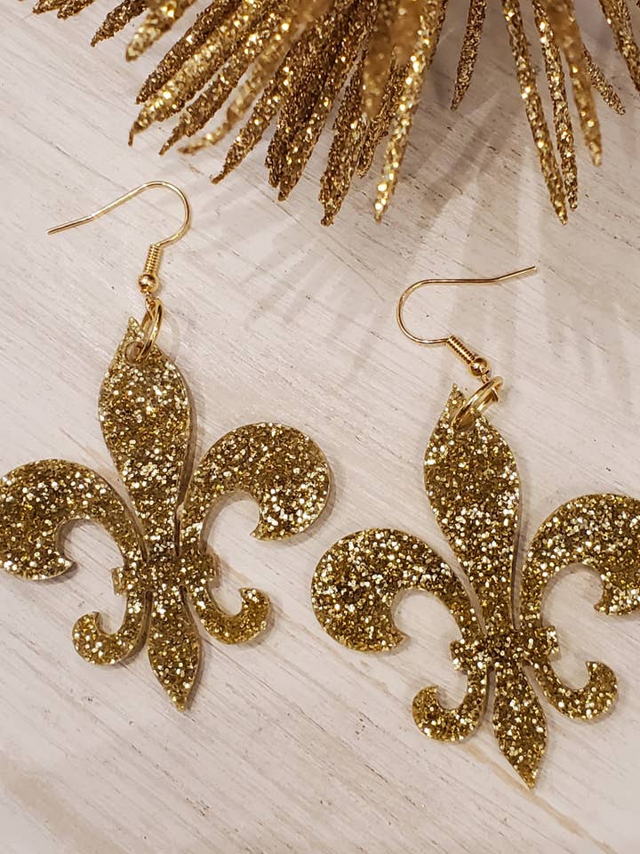 Pendientes Fleur De Lis Pendientes acrílicos con purpurina dorada para venta al por mayor de Maggie G