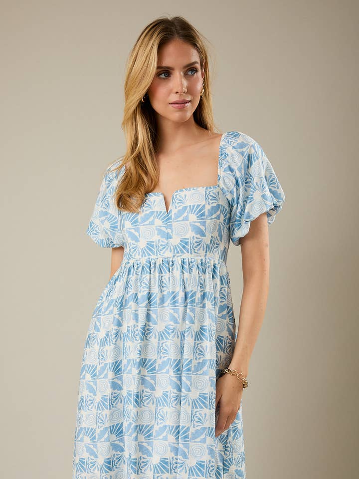 ROBE COURTE ABSTRAITE À MANCHES BOUFFANTES COURTES, DÉCOLLETÉ CARRÉ ET DÉCOUPE EN V. pour la vente par GILLI