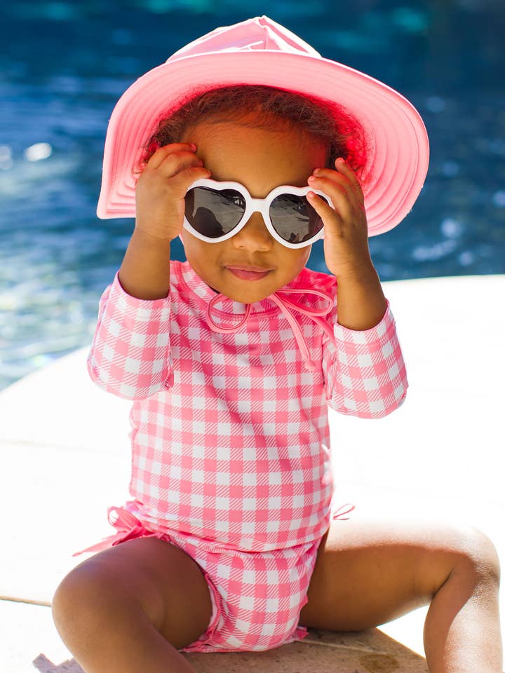 Baby Girls Bubblegum Gingham Long Sleeve One Piece Rash Guard Swimsuit with Signature Rear Ruffles
for wholesale by RuffleButts + RuggedButts