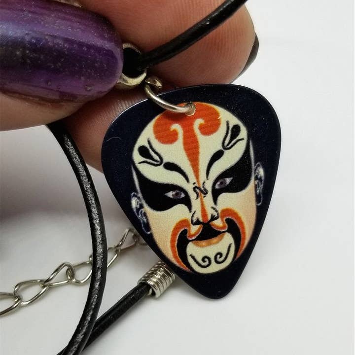 Simply Raevyn – Großhandel Kette mit Anhänger/Charm – Gitarrenplektrum mit chinesischer Opernmaske und schwarzer Kordelkette
