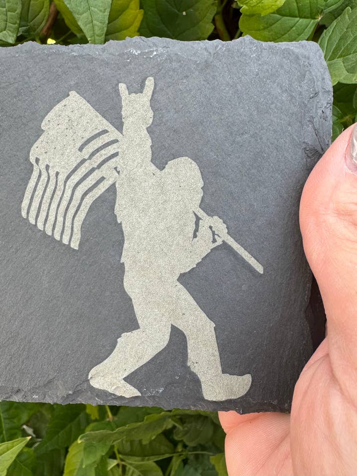 Set med 4 skifferunderlägg | Bigfoot med amerikansk flagga | Lasergraverad | Fyrkantigt underlägg | Bröllopsgåva | Bigfoot-älskare | Sasquatch-gåva för wholesale av Redneckbougie Co