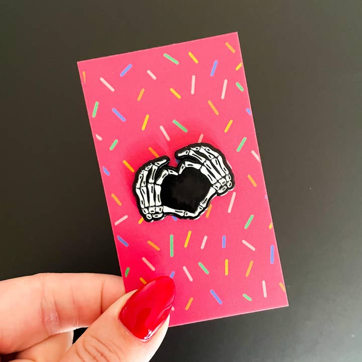 Skeleton Heart Hands Enamel Pin for wholesale by Stark + Stanley