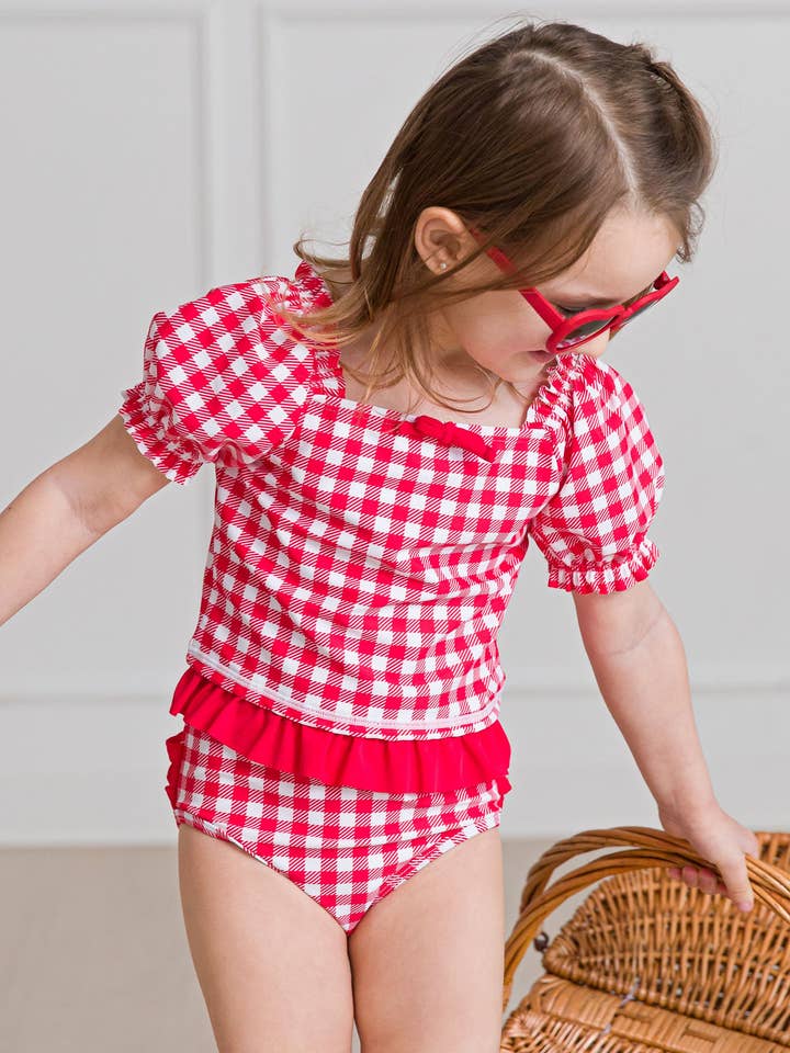 Maillot de bain 2 pièces vintage pour filles à carreaux rouges avec manches bouffantes et volants signature à l'arrière pour la vente par RuffleButts + RuggedButts
