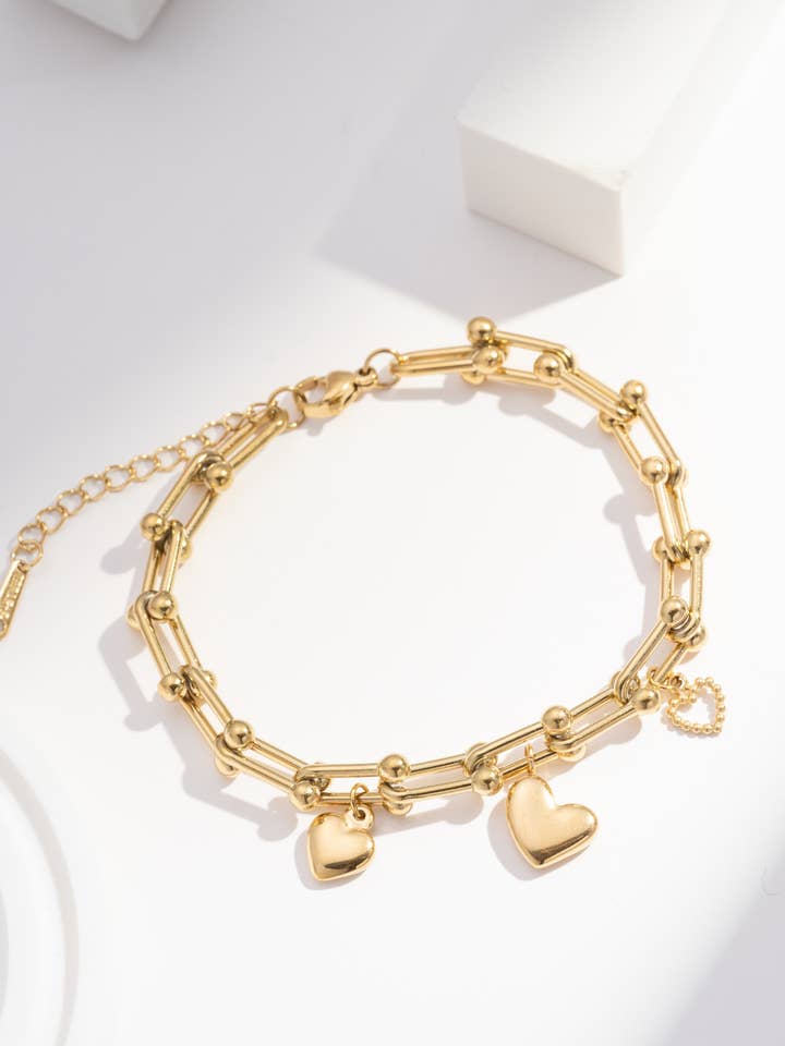Gold bracelet with three stainless steel heart charms for wholesale by COSMOS