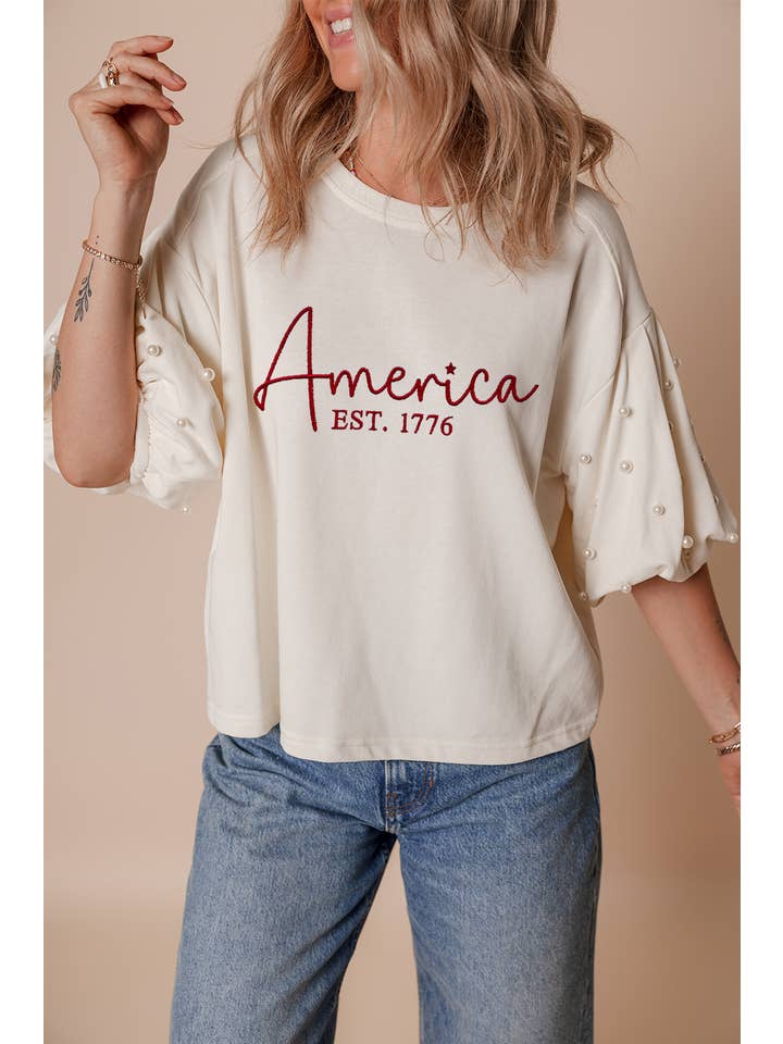 White LDC America EST 1776 Embroidered Pearl Beaded T Shirt for wholesale on Faire