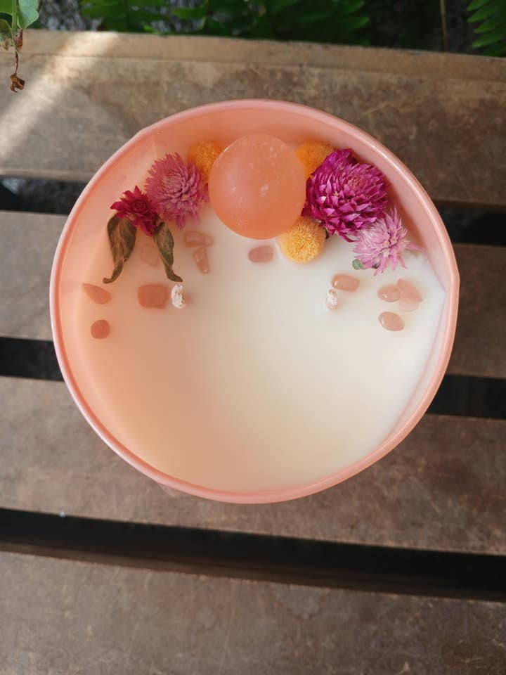 Bougie en cire de soja aux agrumes avec cristaux cachés dans un pot corail pour la vente par moon and mantras