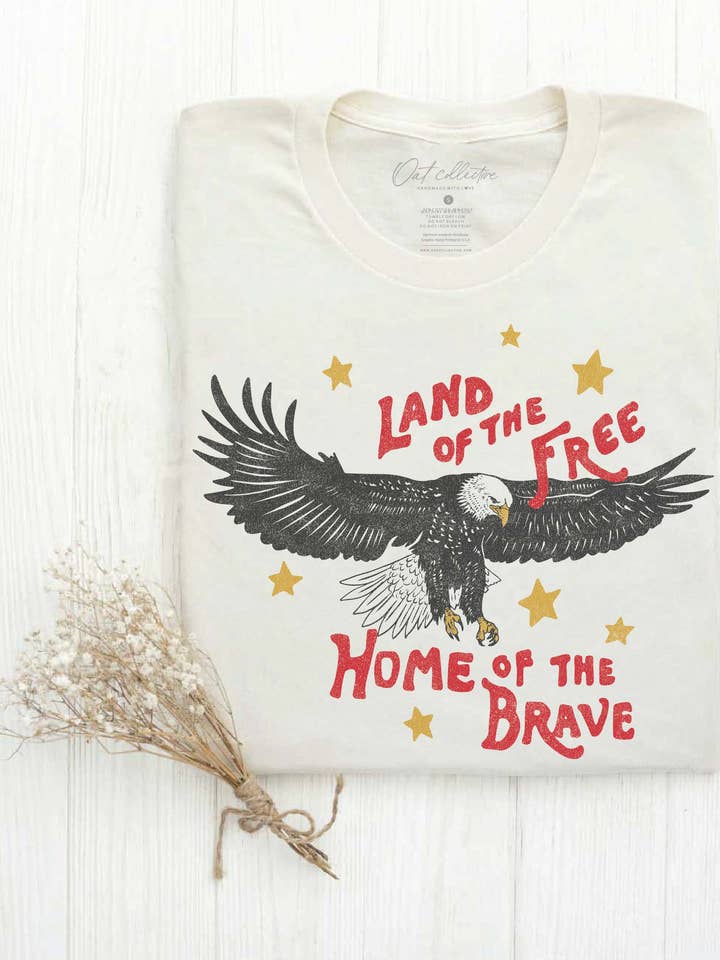 T-shirt graphique LAND OF THE FREE HOME OF THE BRAVE pour la vente par OAT COLLECTIVE