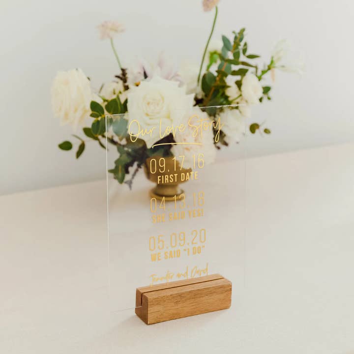 Foil Printed Clear Acrylic Tabletop Sign - Love Story Dates for wholesale by Weddingstar Inc.