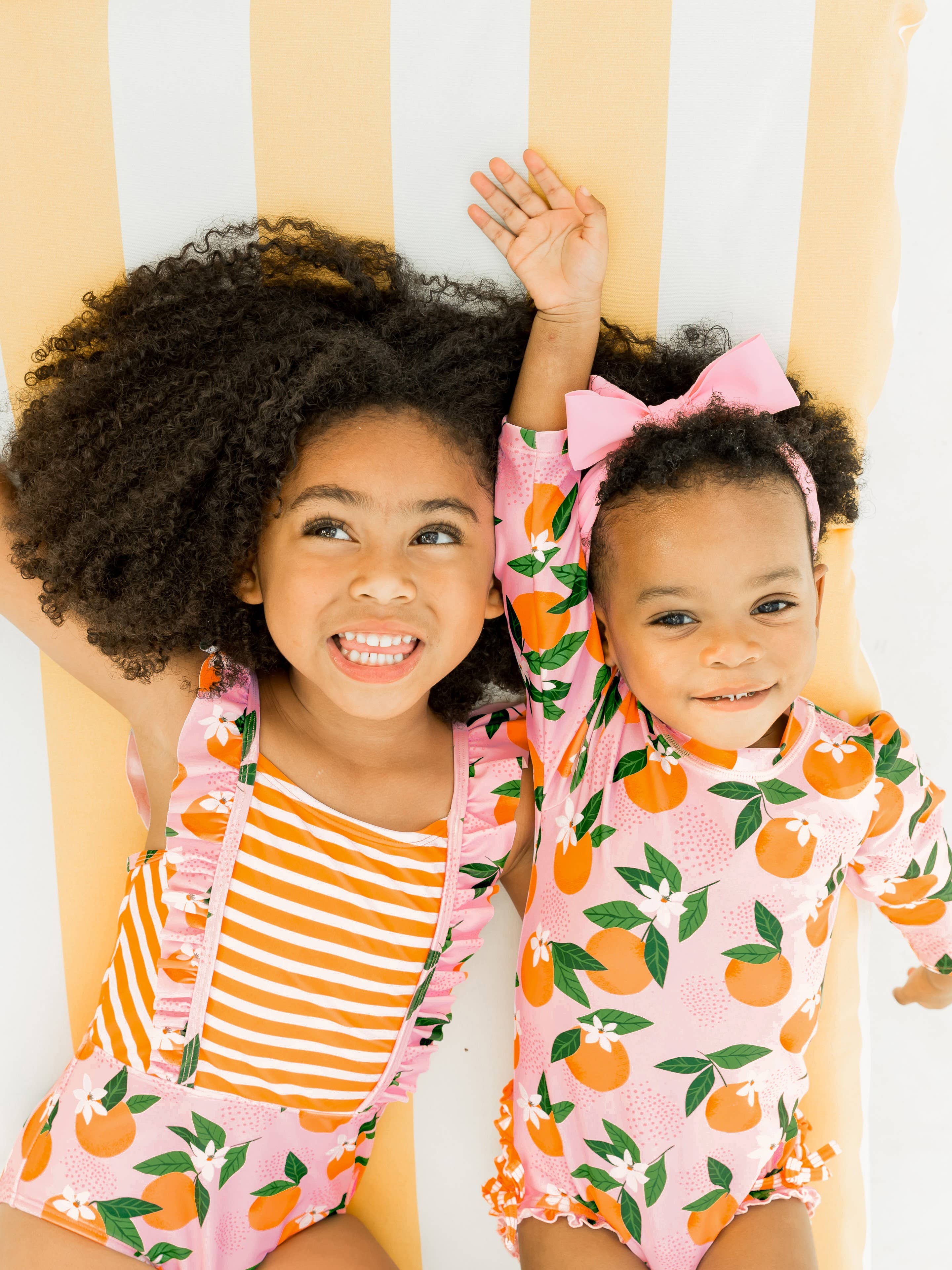 Lyserød Baby Piger Orange You The Sweetest Langærmet Éndelt Rash Guard Badedragt med Signature Bagpå Flæser for engroshandel på Faire3