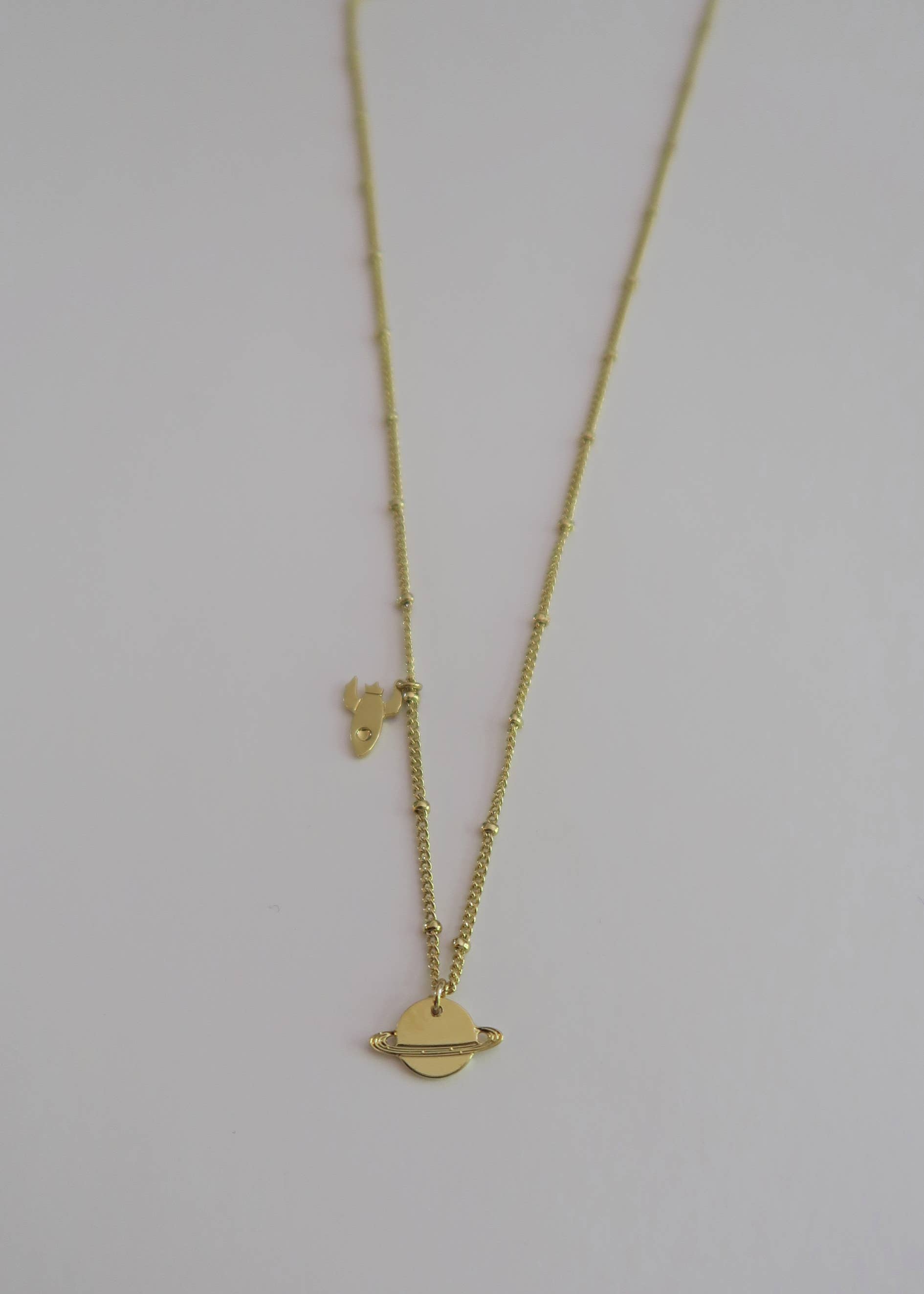 Yellow gold Mini planet Saturn and mini rocket necklace for wholesale on Faire2