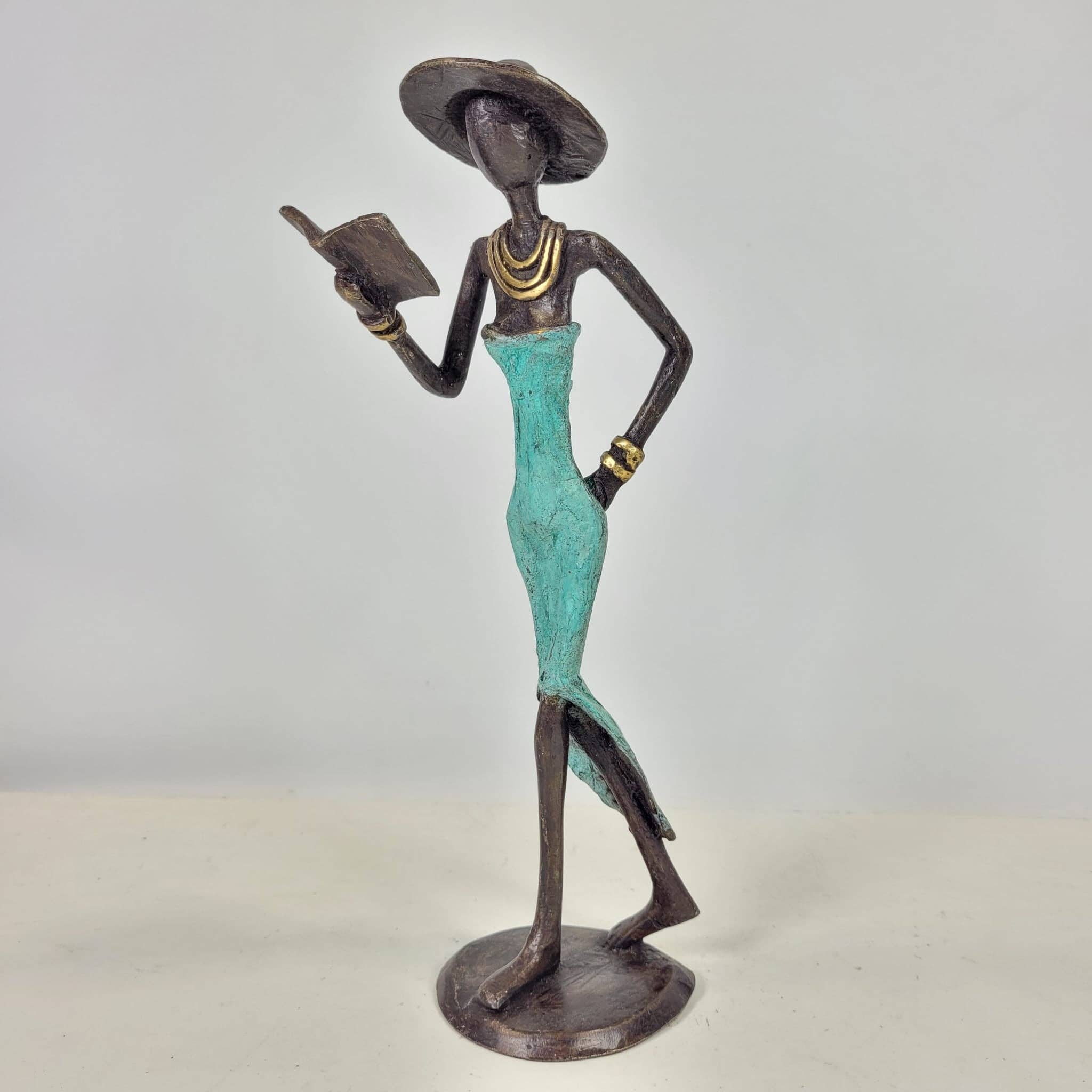 Moogoo Creative Africa - Wholesale Sculpture - Bronze sculpture “Femme avec livre et chapeau” by Soré | vers3