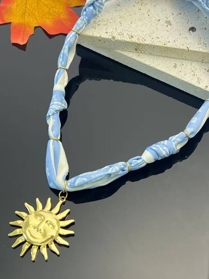 Sky blue scarf necklace, luminous golden sun pendant for wholesale by COSMOS
