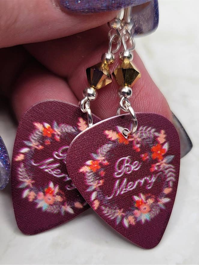 Pendientes Be Merry con forma de púa de guitarra con Swarovski en oro metálico para venta al por mayor de Simply Raevyn