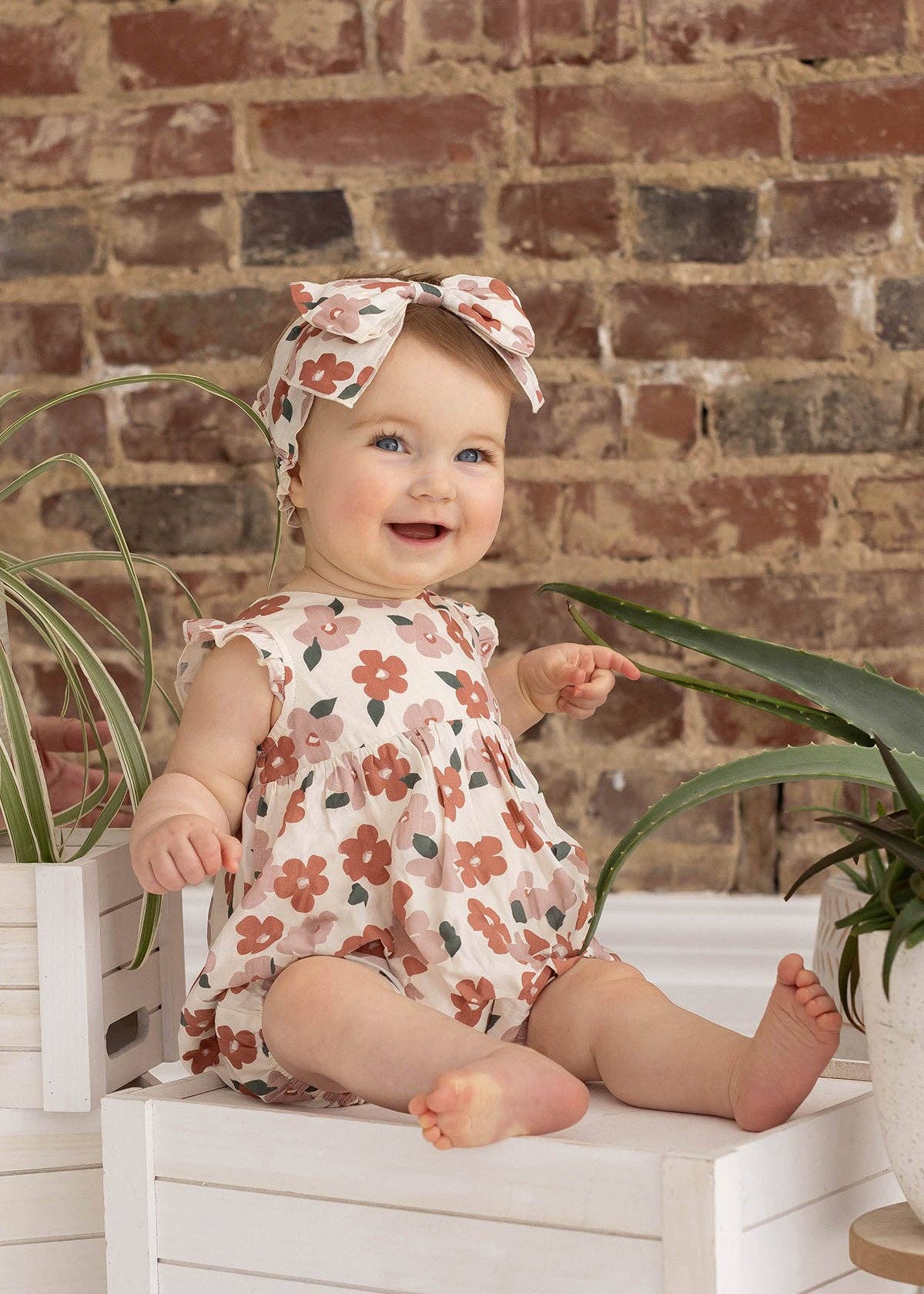 Rosa Mavery babyromper för flickor med mjuka blommönster i jordnära toner för wholesale på Faire