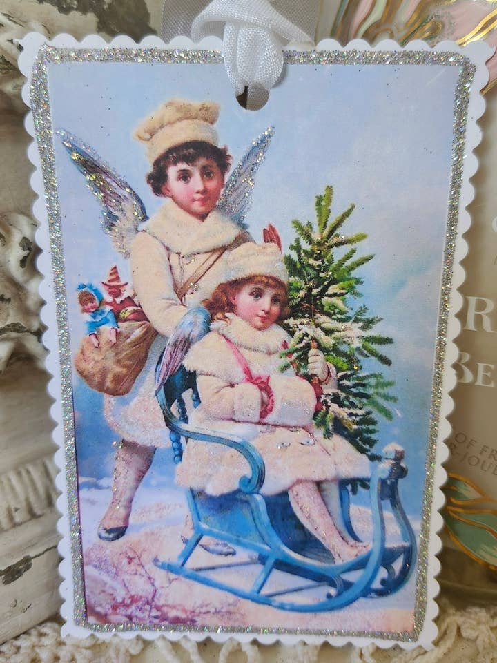 Weihnachtsgeschenkanhänger Boy n Girl Angels On Sleigh für den Großhandel von Little Heart Designs