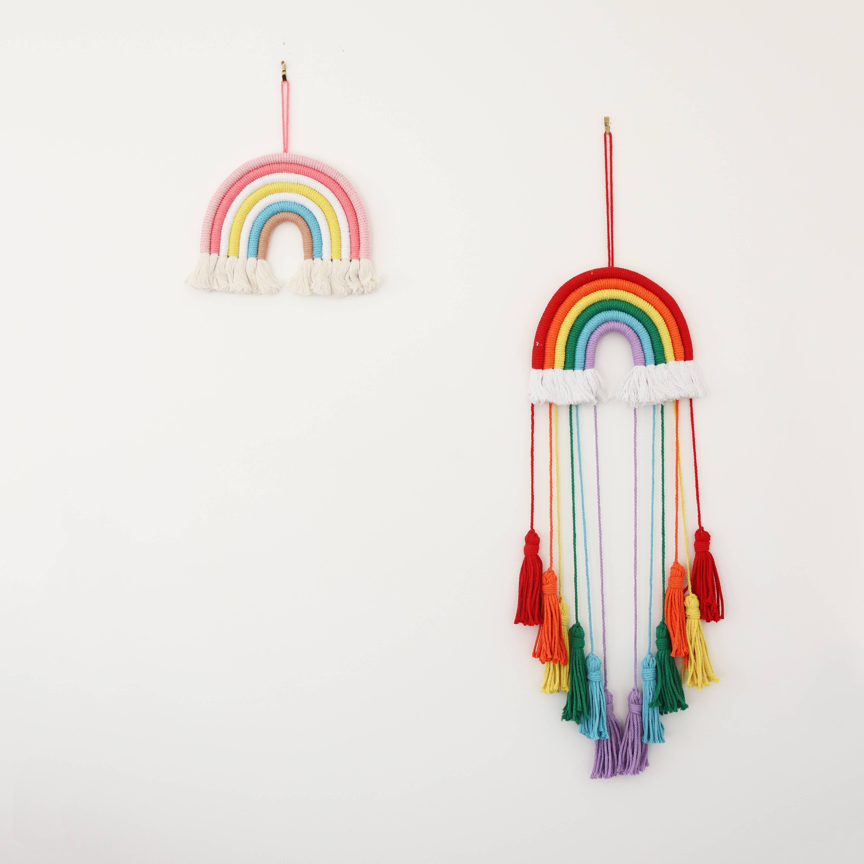 Rosa Decorazione da parete arcobaleno in macramé fatta a mano per cameretta bambini in vendita all'ingrosso su Faire5