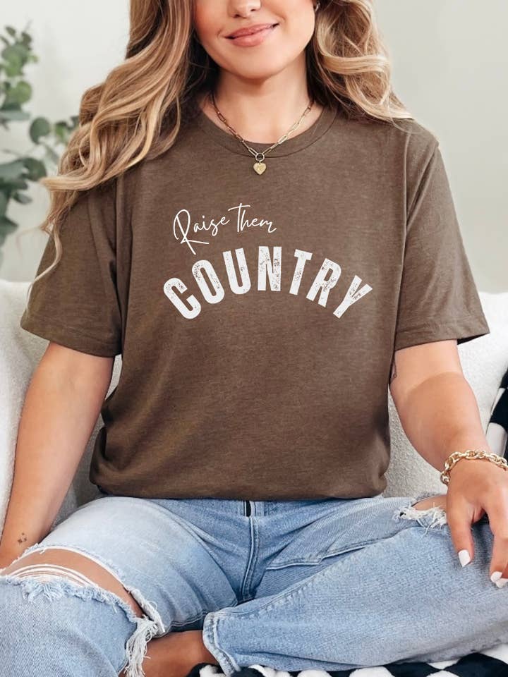 T-shirt graphique "Raise them Country" pour la vente par Rock n' Rodeo