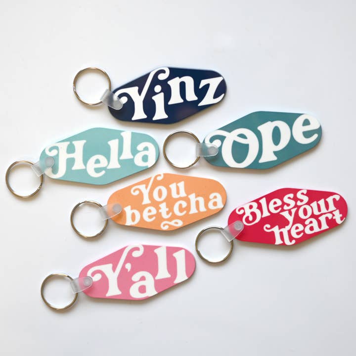 Assortiment de six porte-clés avec dictons régionaux pour la vente par Blue Studio Creative