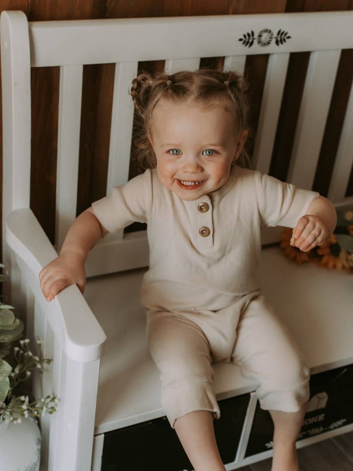 Short evolving cream onesie in ribbed bamboo for wholesale by Kim & Joe