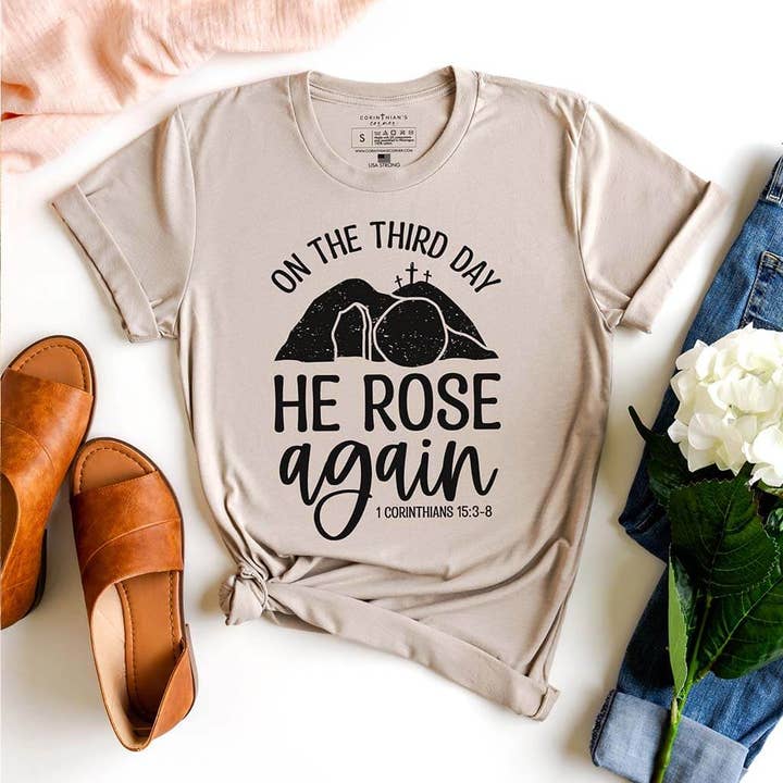 T-shirt con grafica He Rose Again per la vendita all'ingrosso da parte di Corinthian's Corner