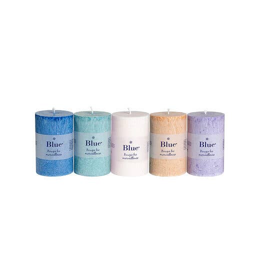 Assorted pastel-colored large cylinder candles in a box for wholesale by Ecodis - Grand Beau