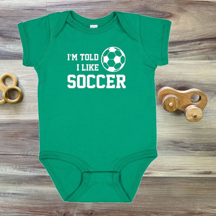 I'm Told I Like Soccer Silhouette Baby Bodysuit for wholesale by Rocket Bug