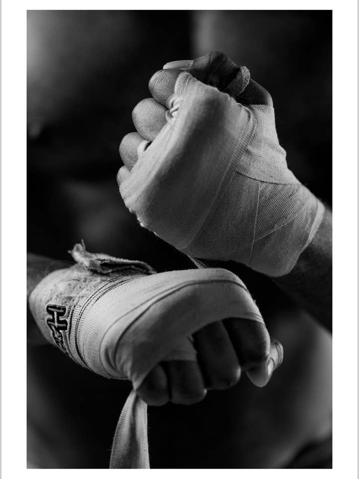 Modieuze zwart-wit foto van een man die zijn handen wikkelt voor het boksen voor wholesale door Arteve Gallery