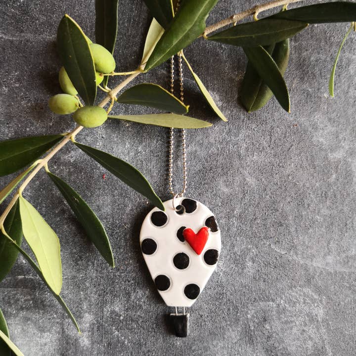 Handmade hot air balloon necklace with black terracotta polka dots for wholesale by Elisa Sasso Ceramiche