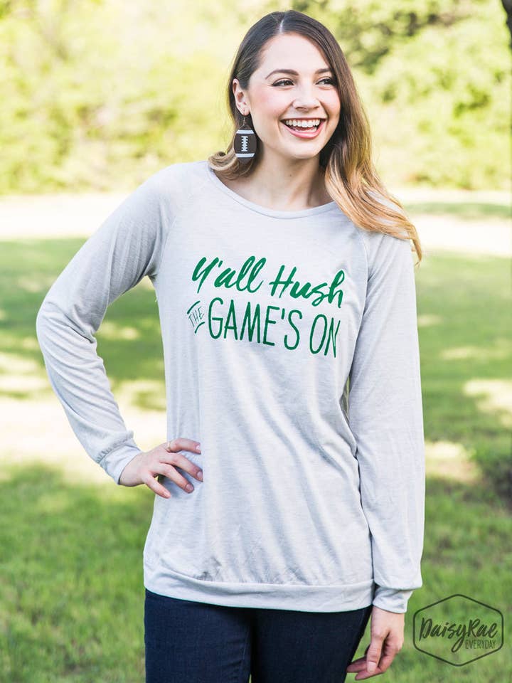 T-shirt gris clair à manches longues Y'all Hush The Game's On, encre verte pour la vente par GRACE+EMMA by Southern Grace