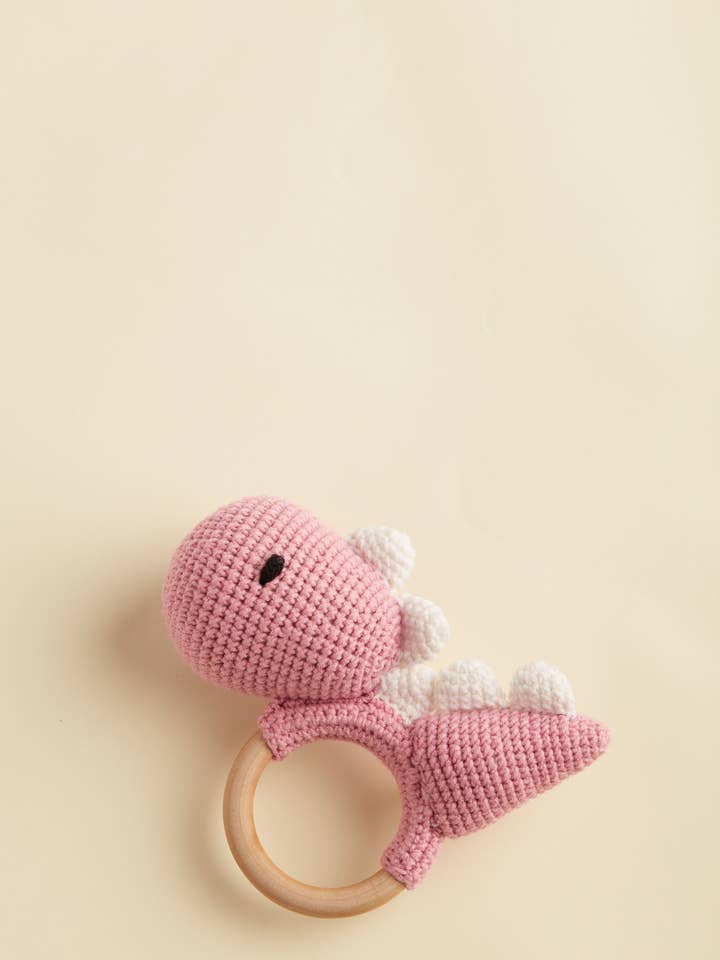 Roze babyrammelaar met dinosaurus voor wholesale door chippico