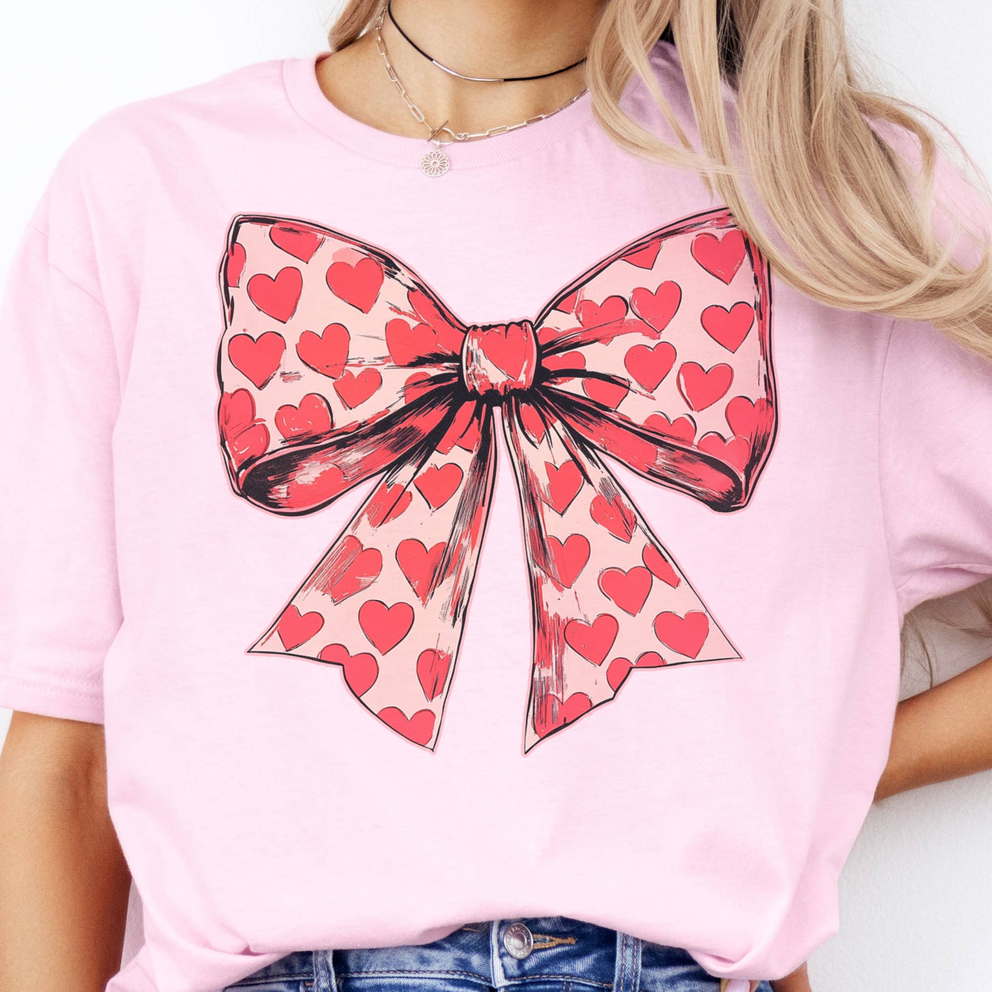 Par.tees by Party On! - Venta al por mayor Camiseta estampada - Unisex - Camiseta gráfica neutral con lazo y corazón rojo de San Valentín coqueta.0