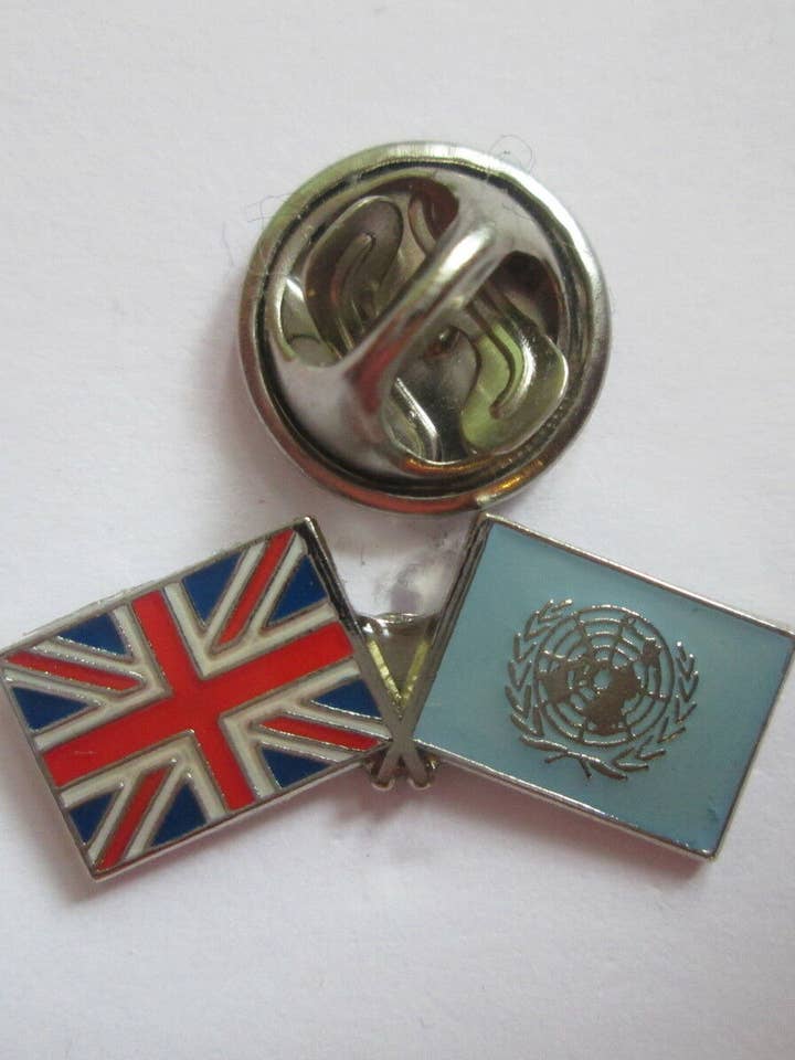 Épinglette en métal émaillé de l'amitié des Nations Unies et du Royaume-Uni pour la vente par jungle brands ltd