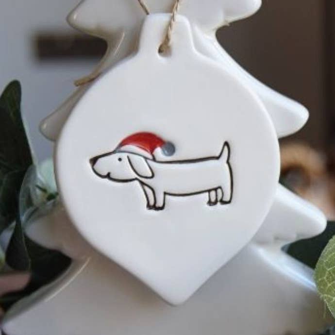Christmas - Dog with Santa Hat - Handmade ceramic bauble for wholesale by Broadlands Pottery