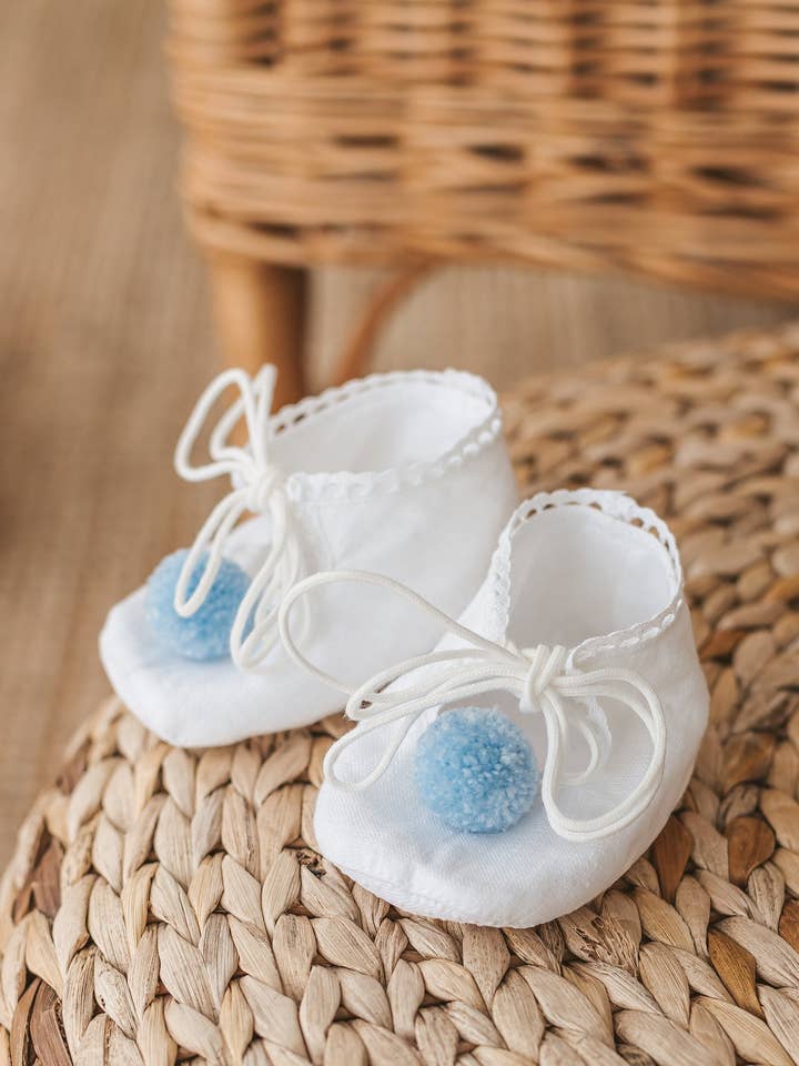 White Linen Newborn Unisex Shoes with Blue Pom Poms for wholesale by Matrinna