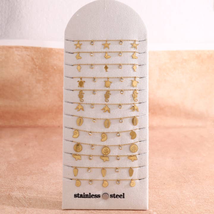 Lot de 12 bracelets dorés thème océan sur présentoir pour la vente par joya