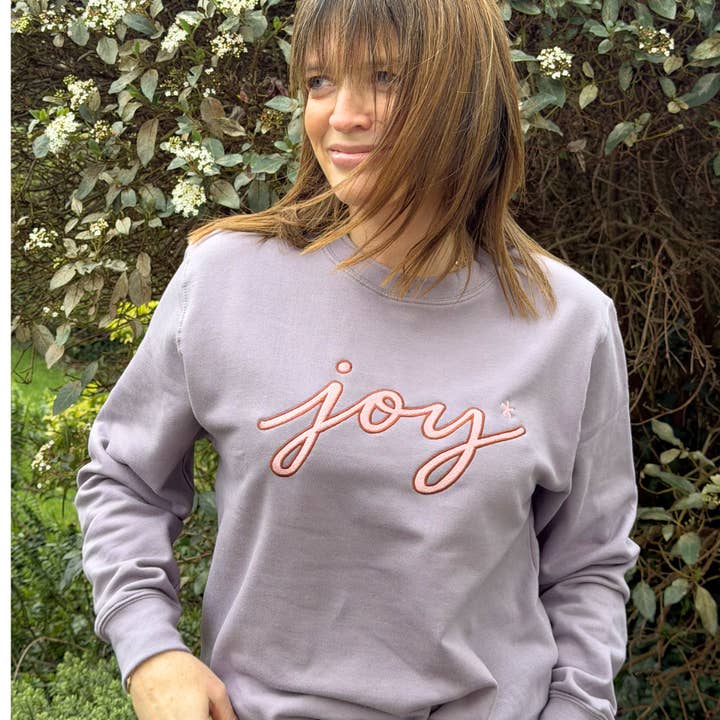 Sweat-shirt brodé « Joy » en lilas poudré pour la vente par Percy and Nell Retail Limited