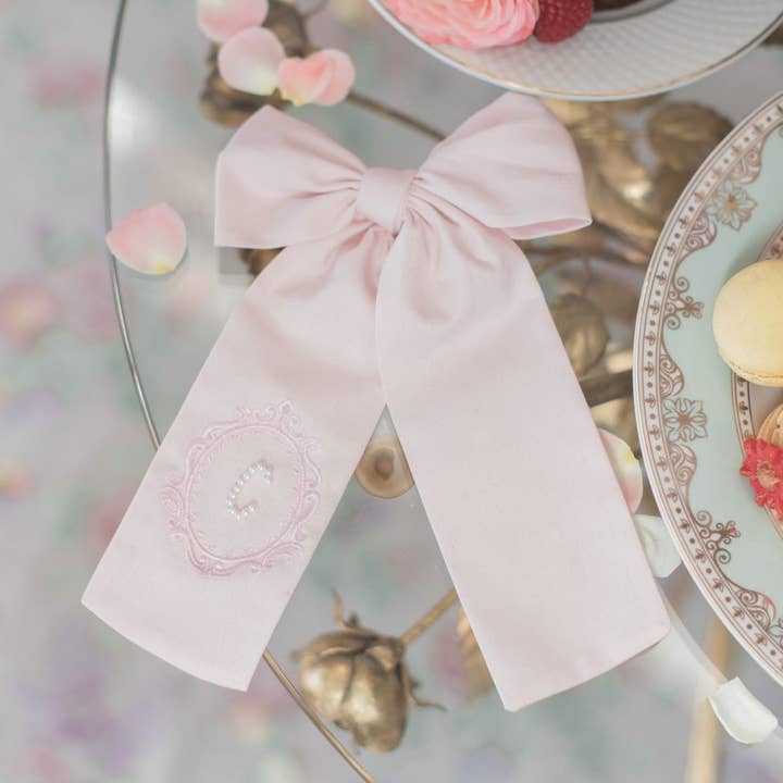 Pink Crest Pearl Initial Bow for wholesale by Bebe Theory
