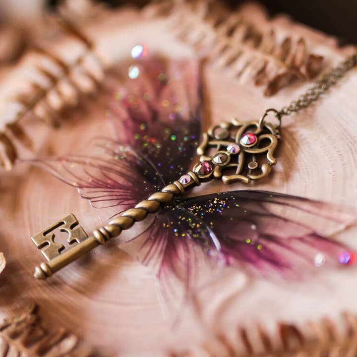 Collana Wyvern Dream con chiave alata e ali di fata nere e viola per la vendita all'ingrosso da parte di Faërie