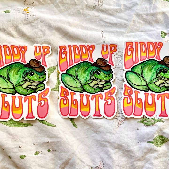 Hollandaize Art - Wholesale Sticker - "Giddy Up Sluts" Cowboy Frog Bumper Sticker