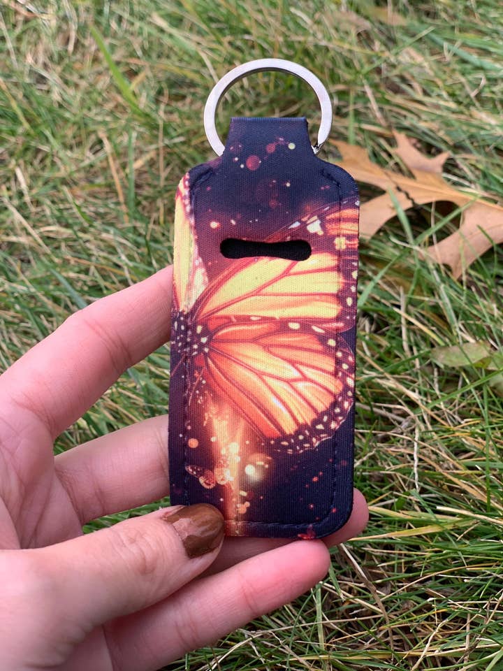 Oranje Gloeiende Vlinder Lippenbalsemhouder – Sleutelhanger voor wholesale door The E Tribe Co.