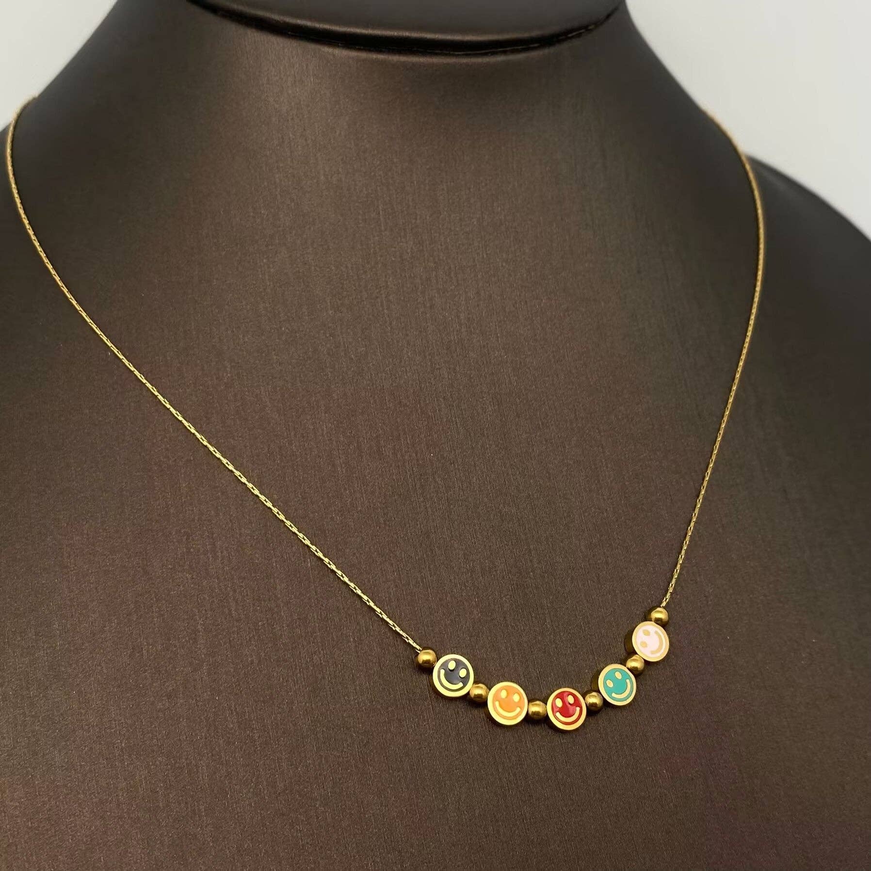 Mio Queena - Vente Colliers à pendentif - Collier en acier inoxydable plaqué or 18K avec 5 visages souriants en émail - FGS0